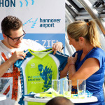 (v.l.): Michael Thellmann (Gewinner Designer-Wettbewerb Jubiläumsshirt), Kerstin Werner (Moderatorin NDR)